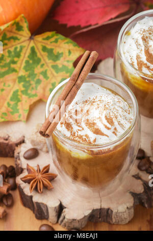 Latte macchiato di zucca o frullati con panna e spezie-cannella, anice stellato, caffè. A freddo o a caldo rientrano bere. Messa a fuoco selettiva Foto Stock