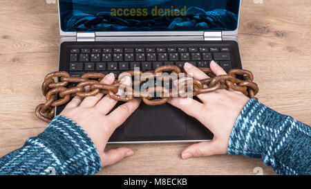 Close-up di mani, tastiera portatile e vecchio arrugginito catene su uno sfondo di legno. Accesso negato. La censura, digitalizzazione, cyber sicurezza, backup, il PILR nell UE Foto Stock