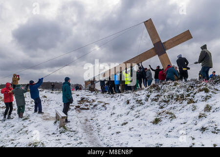 Otley Chevin, Regno Unito, 17 marzo 2018. Su una fredda, mattina nevosa, i volontari dalle chiese locali, usando le corde, sollevano & sollevano l'enorme, pesante, legno, Croce di Pasqua sulla Chevin, un'alta cresta che domina la città di Otley, West Yorkshire, Inghilterra, Regno Unito. Un simbolo cristiano di fede e speranza. Credit: Ian Lamond/Alamy Live News Foto Stock