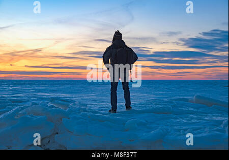 Stati Uniti d'America, Massachusetts, Eastham, Cape Cod, vista posteriore di uomo maturo guardando il mare al tramonto Foto Stock