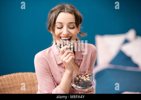 Donna godendo un cioccolato in ambienti interni Foto Stock