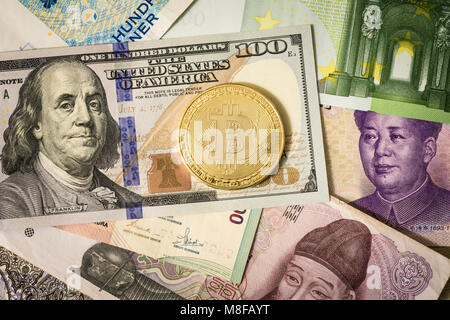 Golden bitcoin su multi valuta banconote dollaro, yuan, euro Foto Stock