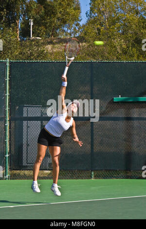 Anna Tatishvili in maglietta grigio e bianco mantello palla da tennis con racket sul soleggiato verde corte. Foto Stock