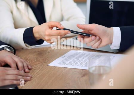 Business donna dando una penna per imprenditore pronto a firmare il contratto. Comunicazione di successo alla riunione o negoziazione Foto Stock