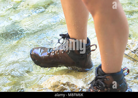 Giovane donna Passeggiate sul fiume con scarponcini da trekking Foto Stock