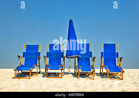 Sedie blu e blu ombrellone su una spiaggia di sabbia bianca con cielo blu Foto Stock