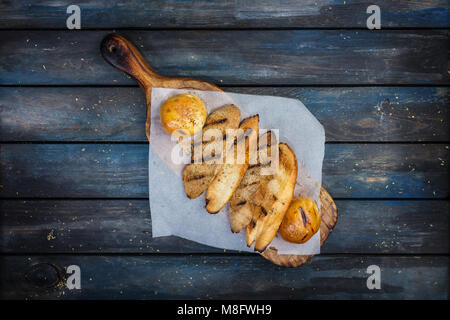 Grigliata di pane tostato sul tagliere. Foto Stock