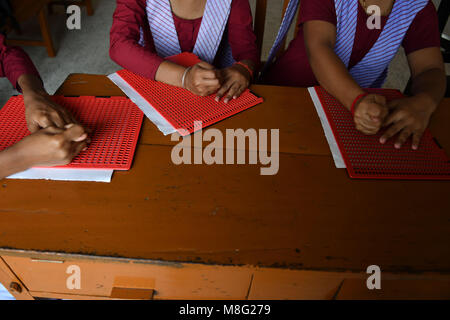 Agartala, India. Xiv Mar, 2018. Tenda indiana le ragazze sono iscritto in una scuola usando il Braille. Il Braille è una forma di linguaggio scritto per persone non vedenti, in cui i caratteri sono rappresentati da modelli di puntini in rilievo che si fanno sentire con la punta delle dita. Credito: Abhisek Saha/Pacific Press/Alamy Live News Foto Stock