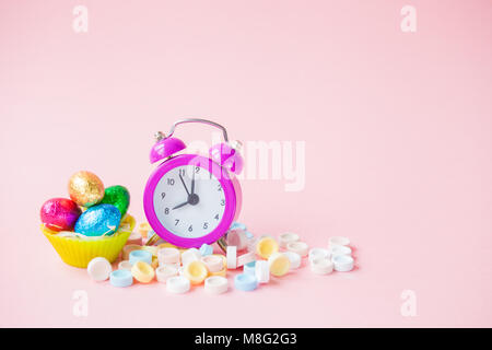Tempo di Pasqua concetto con sveglia del colore di sfondo Foto Stock