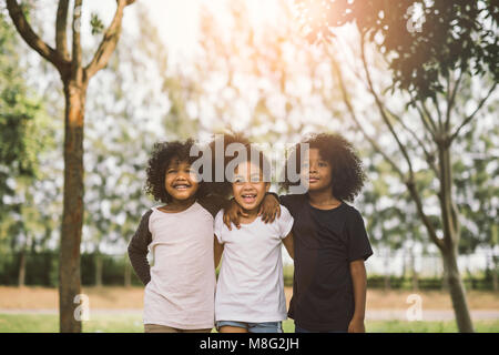 Bambini amicizia stare insieme sorridente felicità concetto.carino americano africano piccolo ragazzo e ragazza abbracciarsi in estate giornata di sole
