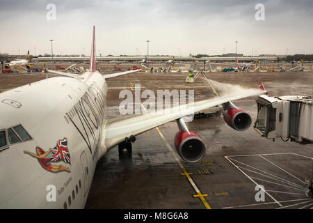 Regno Unito, Inghilterra, Manchester Airport, lavoratori de-icing Virgin Atlantic Boeing 747-41R aeromobile in estremamente freddo inverno Foto Stock