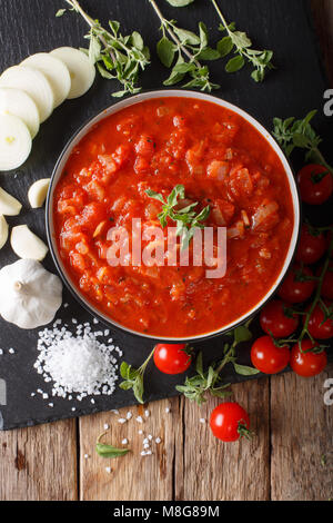 Italiano salsa pizzaiola con ingredienti di close-up sul tavolo. Verticale in alto vista da sopra Foto Stock