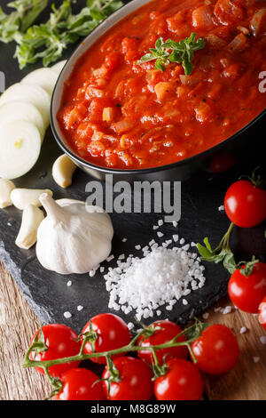 Pomodoro italiano salsa pizzaiola con ingredienti macro sul piano verticale. Foto Stock