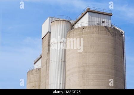 Vecchio cemento sili e cielo blu sullo sfondo Foto Stock