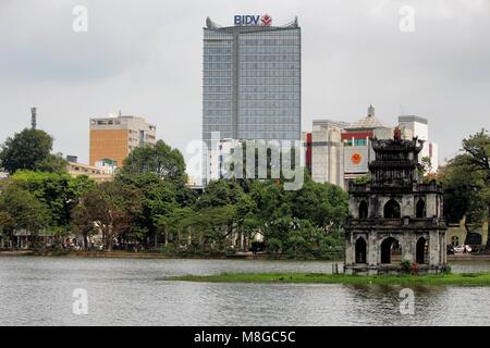 Hanoi, Vietnam - Marzo 15, 2018: strada locale barbiere il taglio dei capelli di un cliente per le strade di Hanoi, 2018: Thap Rua tempio buddista a metà Foto Stock