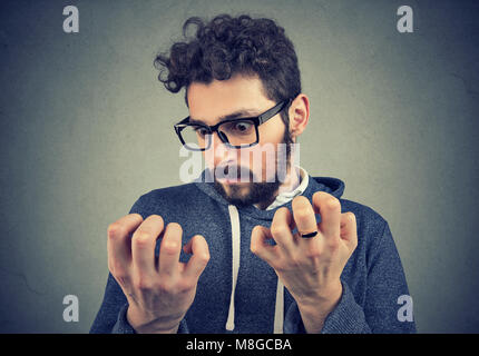 Giovane uomo serio con disturbo ossessivo compulsivo esplorando la pulizia delle mani. Foto Stock