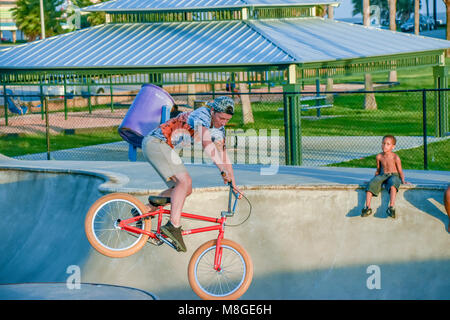 Ragazzi adolescenti sulle loro biciclette BMX pratica salti ad uno skateboard park in Galveston Texas. Foto Stock