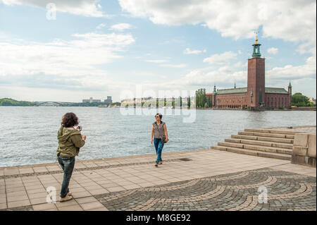 Il turista a godere la vista da Riddarholmen verso il Municipio di Stoccolma. Questo iconico Edificio è la sede per la cerimonia di conferimento del premio Nobel. Foto Stock