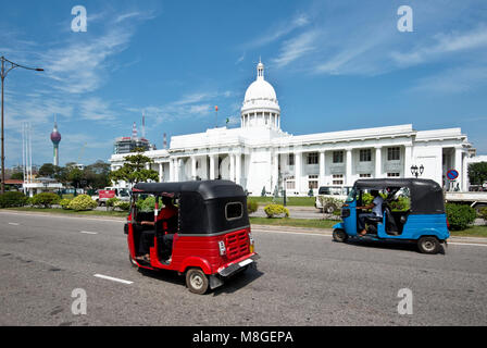 La facciata anteriore della Columbo Municipio aka Town Hall di Colombo in una giornata di sole e cielo blu con 2 tuk tuks guida passato. Foto Stock