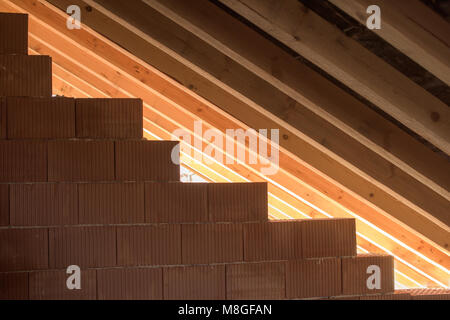 Parte del tetto in legno - muro in mattoni, assi e travi Foto Stock