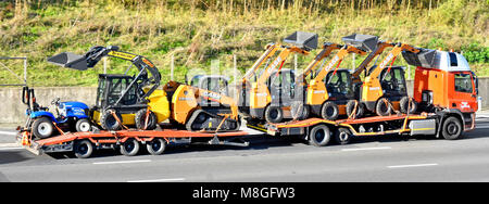 Caricatore basso camion Truck & trasporto del rimorchio caricato con 6 assortimento di nuovo Case e New Holland attrezzatura caricatrice percorrendo l autostrada M25, Essex England Regno Unito Foto Stock