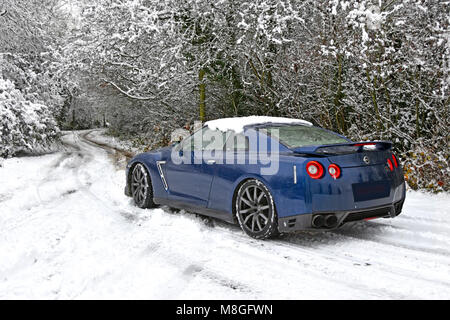 Le cattive condizioni meteo per il pilotaggio di Nissan auto lungo strade coperte di neve vicolo del paese in inverno la neve in scena rurale nevoso Brentwood Essex England Regno Unito Foto Stock