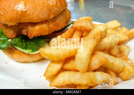 Barramundi (pesce) burger con un lato di patatine fritte. Foto Stock