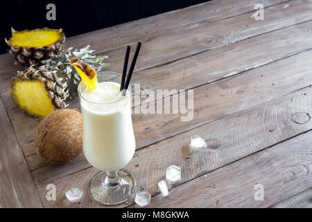 La Pina Colada Cocktail con ananas e noce di cocco su sfondo di legno, copia dello spazio. L'estate tropicale cocktail deliziosi. Foto Stock