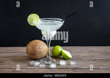 Noce di cocco Сocktail Margarita con calce scuro sul tavolo di legno, copia dello spazio. Bianco o Margarita Daiquiry Cocktail. Foto Stock