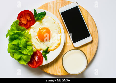 La prima colazione con pane e uova fritte, latte e verdure e pomodoro fritto pezzi isolati su sfondo bianco Foto Stock