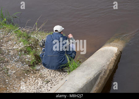 Il giovane uomo che guarda la bellissima vista sul lago Foto Stock