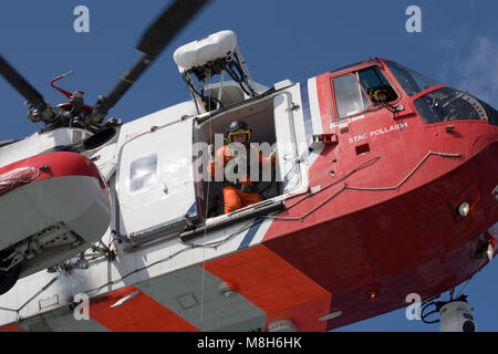 HM Guardia Costiera elicottero Sikorsky effettua una formazione in soccorso il Minch oltre il Caledonian Macbrayne Ulapool a Stornoway ferry. Foto Stock