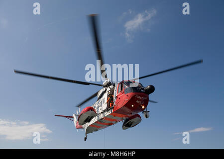 HM Guardia Costiera elicottero Sikorsky effettua una formazione in soccorso il Minch oltre il Caledonian Macbrayne Ulapool a Stornoway ferry. Foto Stock