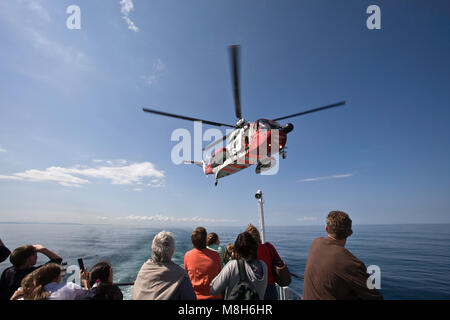 HM Guardia Costiera elicottero Sikorsky effettua una formazione in soccorso il Minch oltre il Caledonian Macbrayne Ulapool a Stornoway ferry. Foto Stock