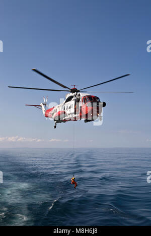 HM Guardia Costiera elicottero Sikorsky effettua una formazione in soccorso il Minch oltre il Caledonian Macbrayne Ulapool a Stornoway ferry. Foto Stock