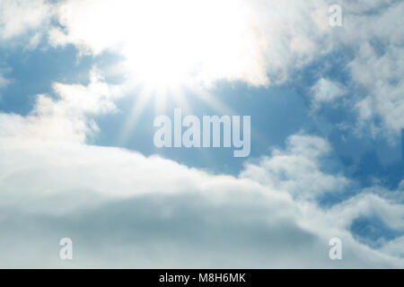 I picchi di sole fuori da dietro le nuvole . Foto Stock