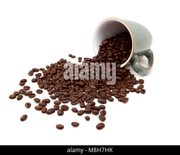 Aromatici chicchi di caffè tostati riversando fuori da un verde cina mug su sfondo bianco Foto Stock