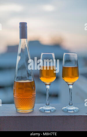 Singola bottiglia con il liquore e due bicchieri Foto Stock