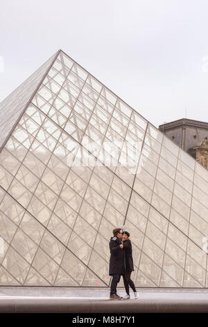 Le persone prendono selfies e le foto a La piramide di vetro ingresso al museo del Louvre a Parigi, Francia Foto Stock