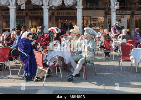 Persone in abiti e maschere di fantasia seduti in bar in Piazza San Marco,  Carnevale di Venezia, Carnevale di Venezia, Veneto, Italia Foto stock -  Alamy