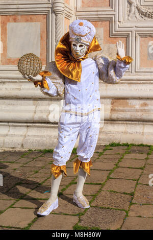 Un indovino e arlecchino o arlecchino in abiti fantasiosi costumi e maschera per il Carnevale di Venezia, Carnivale di Venezia, Italia Foto Stock
