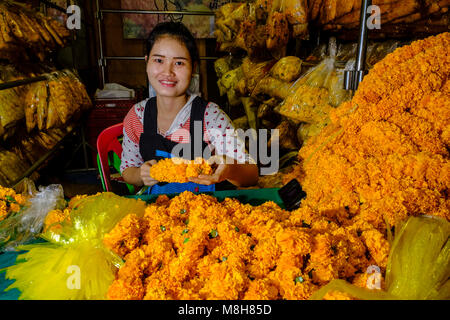 Una giovane donna è disponendo dei fiori e fiorisce in ventiquattro ore il mercato dei fiori Foto Stock