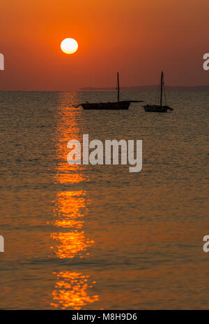 Il sorgere del sole è visto dietro stagliano dhows Inhasurro in Mozambico Foto Stock
