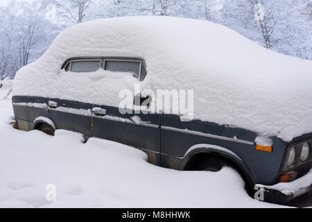 Irriconoscibile auto coperti nello spesso strato di neve nel parcheggio Foto Stock