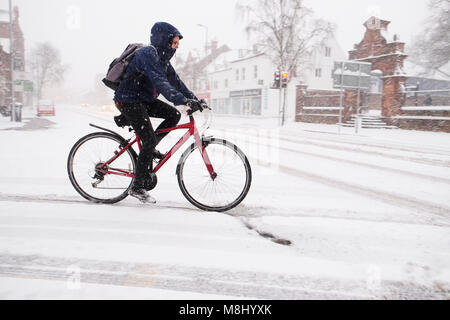 Hereford, Herefordshire, Regno Unito - Domenica 18 Marzo 2018 - città di Hereford nevicata durante la notte continua durante la domenica mattina nella città di Hereford - un ciclista lotte con la caduta di neve. Steven può /Alamy Live News Foto Stock