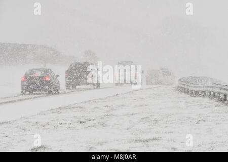 Long Bredy, Dorset, Regno Unito. Il 18 marzo 2018. Regno Unito Meteo. I veicoli le lotte per la presa su per la collina di blizzard condizioni sulla A35 a lunga Bredy tra Bridport e Dorchester nel Dorset come neve pesante che ha coperto la strada, rende la guida pericolosa. Credito Foto: Graham Hunt/Alamy Live News. Foto Stock