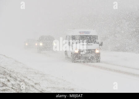 Long Bredy, Dorset, Regno Unito. Il 18 marzo 2018. Regno Unito Meteo. I veicoli le lotte per la presa su per la collina di blizzard condizioni sulla A35 a lunga Bredy tra Bridport e Dorchester nel Dorset come neve pesante che ha coperto la strada, rende la guida pericolosa. Credito Foto: Graham Hunt/Alamy Live News. Foto Stock