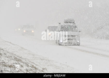 Long Bredy, Dorset, Regno Unito. Il 18 marzo 2018. Regno Unito Meteo. I veicoli le lotte per la presa su per la collina di blizzard condizioni sulla A35 a lunga Bredy tra Bridport e Dorchester nel Dorset come neve pesante che ha coperto la strada, rende la guida pericolosa. Credito Foto: Graham Hunt/Alamy Live News. Foto Stock