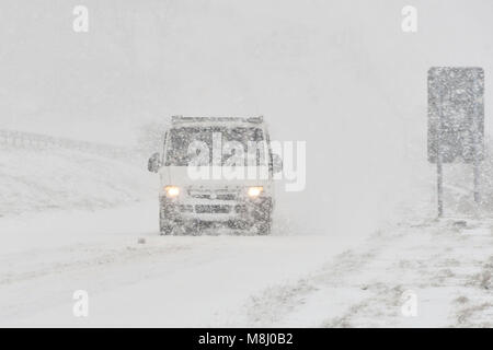 Long Bredy, Dorset, Regno Unito. Il 18 marzo 2018. Regno Unito Meteo. Un furgone di lotte per la presa su per la collina di blizzard condizioni sulla A35 a lunga Bredy tra Bridport e Dorchester nel Dorset come neve pesante che ha coperto la strada, rende la guida pericolosa. Credito Foto: Graham Hunt/Alamy Live News. Foto Stock