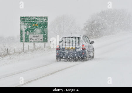 Long Bredy, Dorset, Regno Unito. Il 18 marzo 2018. Regno Unito Meteo. Condizioni di Blizzard sulla A35 a lunga Bredy tra Bridport e Dorchester nel Dorset come neve pesante che ha coperto la strada, rende la guida pericolosa. Credito Foto: Graham Hunt/Alamy Live News. Foto Stock